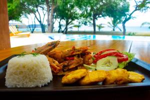 a plate of food with rice and meat and vegetables at Hosteria del Parque Machalilla - Los Frailes in Machalilla