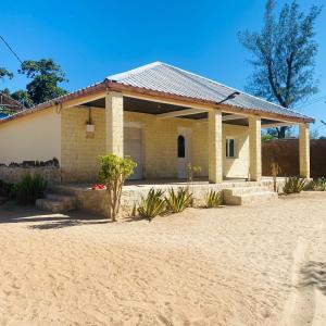 a house on a sandy beach with a building at Le Jardin du soleil in Ifaty