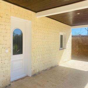 a white door on a brick wall with a window at Le Jardin du soleil in Ifaty +2 photos