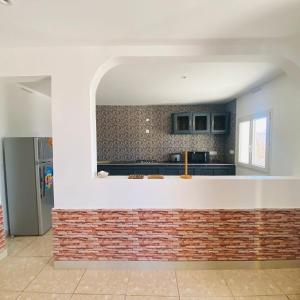 a kitchen with a brick wall and a sink at Le Jardin du soleil in Ifaty