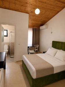 a bedroom with a large bed and a bathroom at Zador Hotel in Ksamil