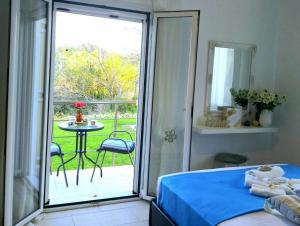 a bedroom with a bed and a balcony with a table at Casa di Helena Luxury villa Corfu in Antipernoí +65 photos