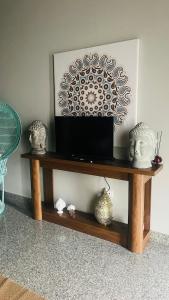 a tv on a wooden shelf with vases on it at Cerchio di Luce in Locorotondo