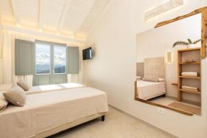 a bedroom with a bed and a mirror at Marinaio di foresta Bedroom in Baunei