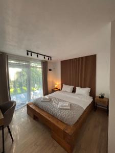 a bedroom with a large bed and a large window at Woodland Retreat in Ampoiţa +17 photos