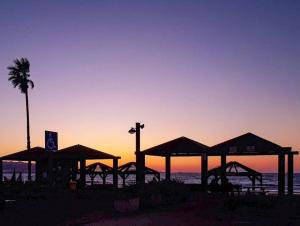a group of umbrellas on the beach at sunset at Coastal Comfort in Haifa