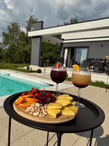 a plate of food on a table with two drinks at Aurora Noir Retreat in Banja Luka