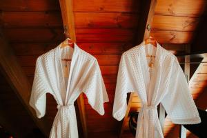 two white robes are hanging on a wall at Lumine Cabanas- Chalé na Serra Gaúcha in Farroupilha +37 photos