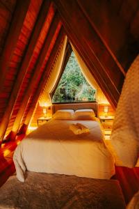 a bedroom with a bed and a window at Lumine Cabanas- Chalé na Serra Gaúcha in Farroupilha