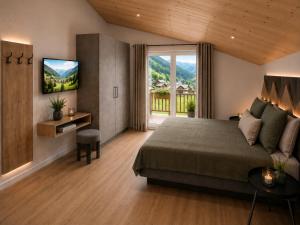 a bedroom with a bed and a tv and a couch at Villa Erika - NEW Luxury Alpine Apartments from December 2026 in Sesto