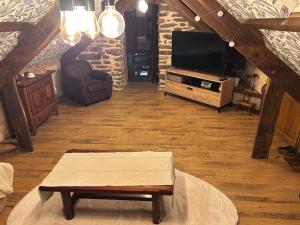 a living room with a tv and a coffee table at Le Breizh des Bois in Le Faouët