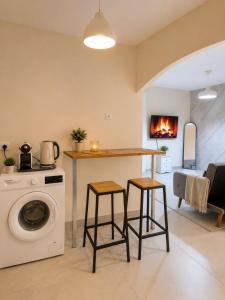 a kitchen with a washing machine and two bar stools at Coastal Comfort in Haifa