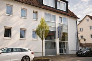 a white car parked in front of a building at Hotel am Hirschgarten in Filderstadt
