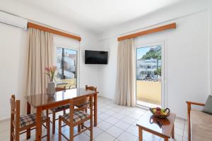 a living room with a dining room table and a window at Rosmaris Apartments in Platanias