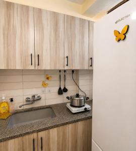 a kitchen with wooden cabinets and a sink at Coastal Comfort in Haifa +1 photo