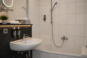 a bathroom with a sink and a shower and a tub at Hotel am Hirschgarten in Filderstadt +23 photos