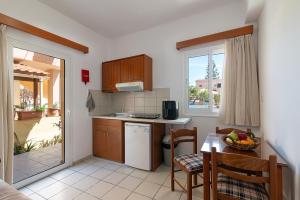 a kitchen with a small table and a kitchen with a tableablish at Rosmaris Apartments in Platanias