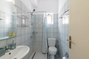a white bathroom with a toilet and a sink at Rosmaris Apartments in Platanias +27 photos