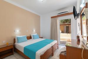 a bedroom with a bed and a large window at Rosmaris Apartments in Platanias