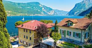 a house with a view of the water and mountains at La dolce riva - lake Cottage in Onno