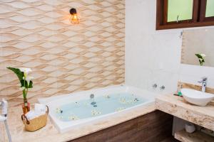 a bathroom with a tub and a sink at Pousada Medeiros in Monte Verde