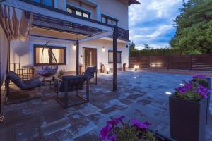 a patio with chairs and a table in a house at Silentium Apartment in Donji Prozor