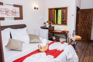a bedroom with a bed and a kitchen with a table at Pousada Medeiros in Monte Verde