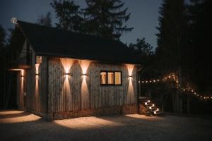 a small cabin with lights on it at night at Nitaure Glamping in Viļums
