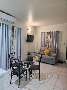 a living room with a table and chairs and a couch at Riseland Breeze Collection in Carnbee Village