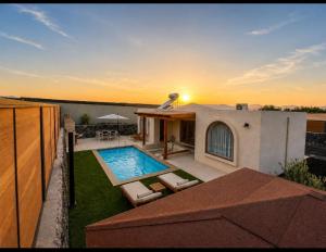 a backyard with a swimming pool and a house at Villa Yeguna - Piscina climatizada in Tuineje