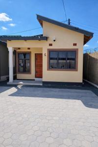 a house with a driveway in front of it at Peaceful Home Self-catering Solar Backed Apartment in Lusaka