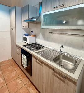 a kitchen with a sink and a microwave at Casa Bella - Ortigia & Neapolis in Syracuse +5 photos