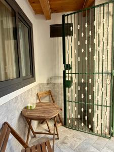 a table and a chair next to a glass door at Casa Bella - Ortigia & Neapolis in Syracuse