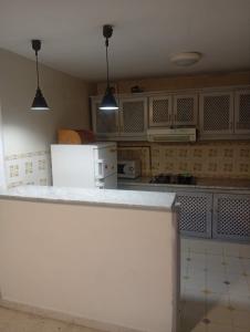 a kitchen with a white counter and a white refrigerator at Summer House in Dar Salah Bey