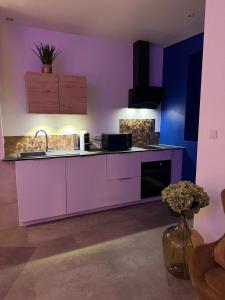 a purple kitchen with a sink and a counter at Les Nuits Douces in Bitche