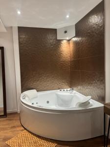 a white bath tub in a bathroom with a wall at Les Nuits Douces in Bitche +36 photos
