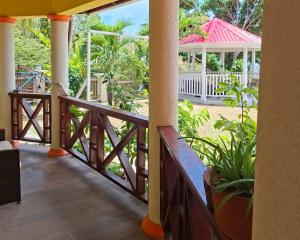 a balcony with a wooden railing and a gazebo at Eden Crest Villa in Anse La Raye