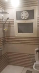 a bathroom with a shower with a window and a toilet at جسر السويس نفرتاري in Obour