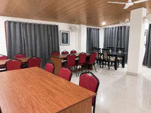 a conference room with red chairs and tables and curtains at The Happy Nest- A Boutique Stay only 7 mins from Nemcare, Apollo, Physicswalla, Allen in Guwahati