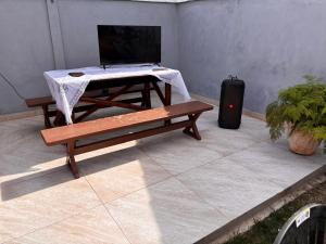 a table and a bench with a laptop on it at Casa Branca in Saquarema