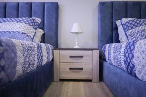 a bedroom with two beds and a nightstand with a lamp at Dreamscape Villa in Ponta Delgada
