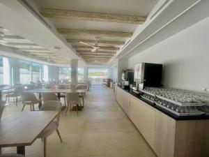 a dining room with tables and chairs and a counter at Lago Playa in Es Pujols