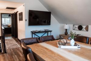 a dining room with a table and a television on the wall at Made with Love in Thackerville