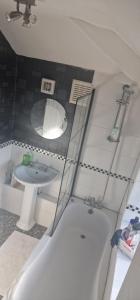 a bathroom with a white tub and a sink at 4 Boteler Avenue,Bewsey in Warrington