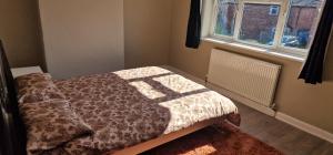 a bedroom with a bed with a comforter and a window at 4 Boteler Avenue,Bewsey in Warrington