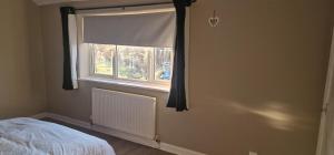 a bedroom with a window with a bed and a radiator at 4 Boteler Avenue,Bewsey in Warrington