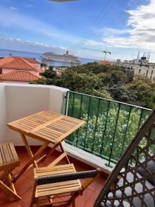 a wooden table and chairs on a balcony with a view at Madeira Ocean View in Funchal
