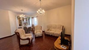 a living room with chairs and a table and a tv at Madeira Ocean View in Funchal