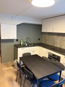 a kitchen with a table and chairs and a sink at Wergelandsvegen 40B in Stjoerdal