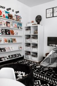 a room with white shelves and a clock on the wall at Made with Love in Thackerville +4 photos